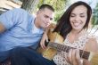 Mixed Race Couple at the Park Playing Guitar and Singing