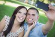 Mixed Race Couple Taking Self Portrait in Park