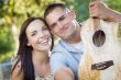 Mixed Race Couple Portrait with Guitar in Park