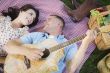 Mixed Race Couple at the Park Playing Guitar and Singing