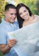 Mixed Race Couple Looking Over Map Outside Together