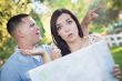 Lost and Confused Mixed Race Couple Looking Over Map Outside