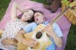 Mixed Race Couple at the Park Playing Guitar and Singing