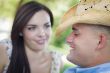 Mixed Race Romantic Couple with Cowboy Hat Flirting in Park