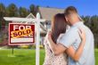 Sold For Sale Sign with Military Couple Looking at House