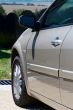 Side front of the car with a mirror and a wheel
