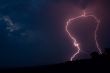 Lightning bolt striking in the sky from clouds