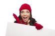 Surprised Girl Wearing Winter Hat and Gloves Holds Blank Sign 