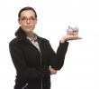 Mixed Race Businesswoman Holding Small House to the Side