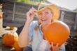 Beautiful Blond Female Rancher Wearing Cowboy Hat Holds a Pumpki