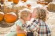 Sweet Little Boy Kisses His Baby Sister at Pumpkin Patch