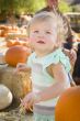 Adorable Baby Girl Having Fun at the Pumpkin Patch