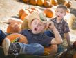 Two Little Boys Playing in Wheelbarrow at the Pumpkin Patch