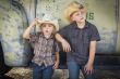 Two Young Boys Wearing Cowboy Hats Leaning Against Antique Truck