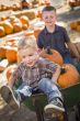Two Little Boys Playing in Wheelbarrow at the Pumpkin Patch