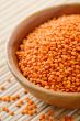 Wooden bowl full of red lentils