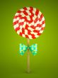Lollipop with bow on green background