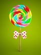 Reainbow lollipop with bow on green background