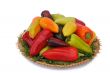 Red, yellow and green peppers on the wicker dish on a white back