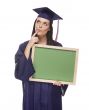 Thinking Female Graduate in Cap and Gown Holding Blank Chalkboar