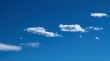 A horizontal shot of bright blue sky with puffy white clouds.