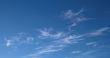 A horizontal shot of bright blue sky with puffy white clouds.