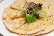 garlic pita bread pizza with salad on top