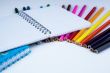 a stack of colored pencils with notebook