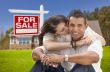 Hispanic Couple, New Home and For Sale Real Estate Sign