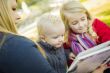 Mother Reading a Book to Her Two Adorable Blonde Children