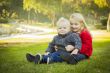 Little Girl with Baby Brother Wearing Coats at the Park