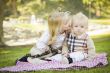 Sweet Little Girl Kisses Her Baby Brother at the Park