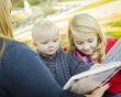 Mother Reading a Book to Her Two Adorable Blonde Children