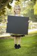 Cute Little Blonde Girl Holding a Black Chalkboard Outdoors