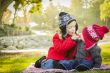 Little Girl with Baby Brother Wearing Coats and Hats Outdoors
