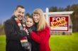 Family in Front of Sold Real Estate Sign and House