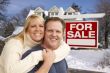 Couple in Front of New House and Real Estate Sign