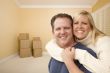 Happy Affectionate Couple in Room of New House with Boxes