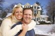 Couple in Front of Beautiful House with Snow on Ground