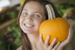 Pretty Young Girl Having Fun with the Pumpkins at Market