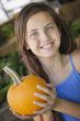 Pretty Young Girl Having Fun with the Pumpkins at Market