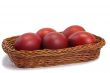 Red Easter eggs in a basket on a white background.