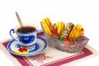 Cup of tea , candies and cakes in a wicker basket.