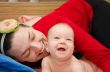 Laughing baby playing with mother