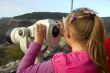 Girl looks into the distance through a telescope