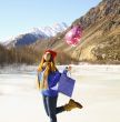 Happy girl with a balloon and a package with a gift on the backg