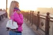 Beautiful young blond woman walking on bridge