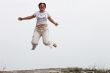 Adult smiling woman in white jumping outdoor