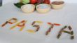 Word PASTA with vegetables and cereals in the background