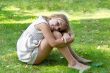 Cute girl sitting on green grass
